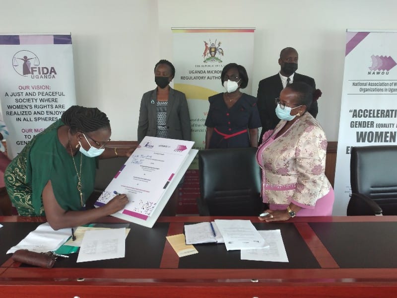 UMRA, FIDA, and NAWOU Sign MOU towards Geared Consumer Protection Ms Edith Tusubira UMRA ED signing the document 1